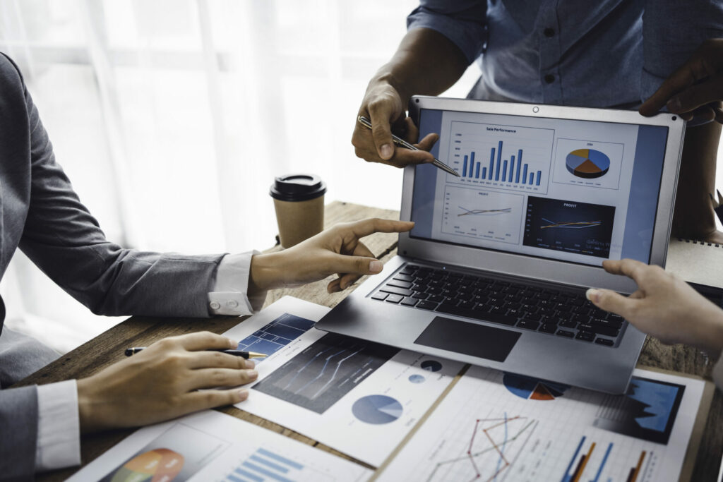 Business people consulting and planning and analyzing marketing on laptop computer in office.